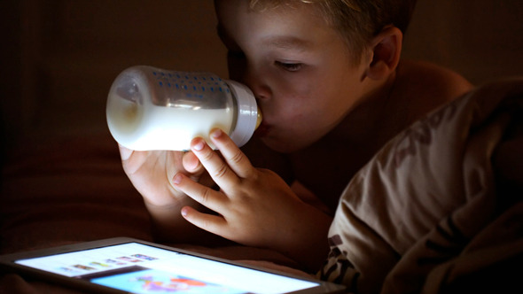 Boy Drinking Milk Looking At Touchpad Boy Drinking Milk Looking At Touchpad