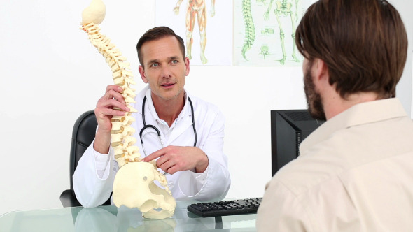 Doctor Showing His Patient A Model Of A Spine Doctor Showing His Patient A Model Of A Spine