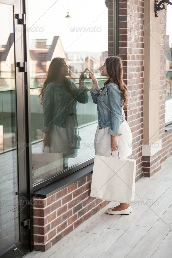 woman with shopping bag looking at shop windows (Misc) Photo Download