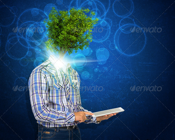 Man hold tablet pc. Green tree and bright light instead his head (Misc) Photo Download