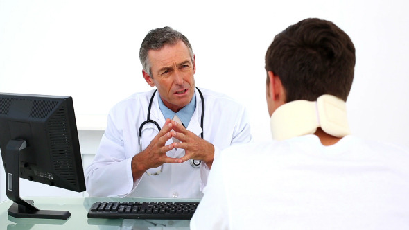 Patient In Neck Brace Listening To His Doctor Patient In Neck Brace Listening To His Doctor