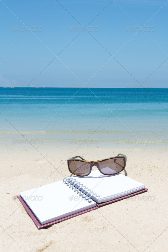 Beach summer time,book sunglass on white sand beach