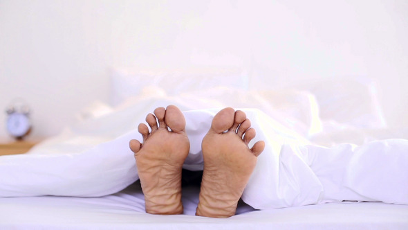 Man Wiggling His Toes Under The Duvet Man Wiggling His Toes Under The Duvet