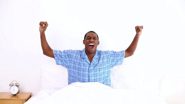Happy Man Yawning And Stretching Sitting In Bed 2 Happy Man Yawning And Stretching Sitting In Bed 2