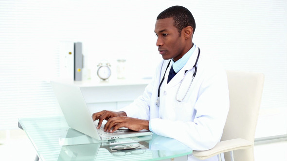 Serious Doctor Working On His Laptop Serious Doctor Working On His Laptop