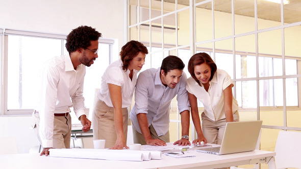 Team Of Architects Going Over Blueprints 1 Team Of Architects Going Over Blueprints 1