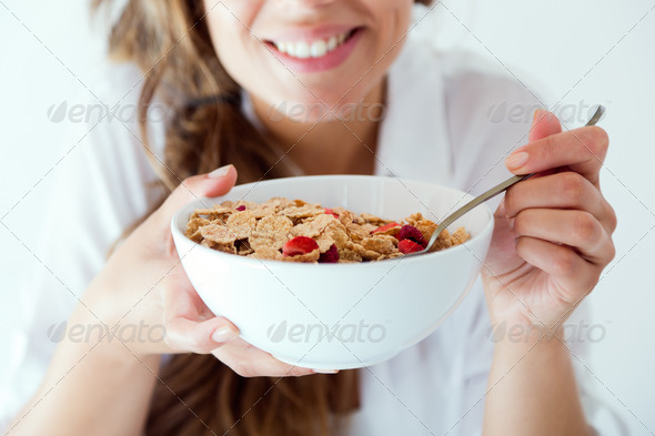 Young woman in underwear eating cereals. Isolated on white. (Misc) Photo Download