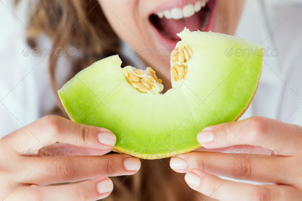 Young woman in underwear eating melon. Isolated on white. (Misc) Photo Download