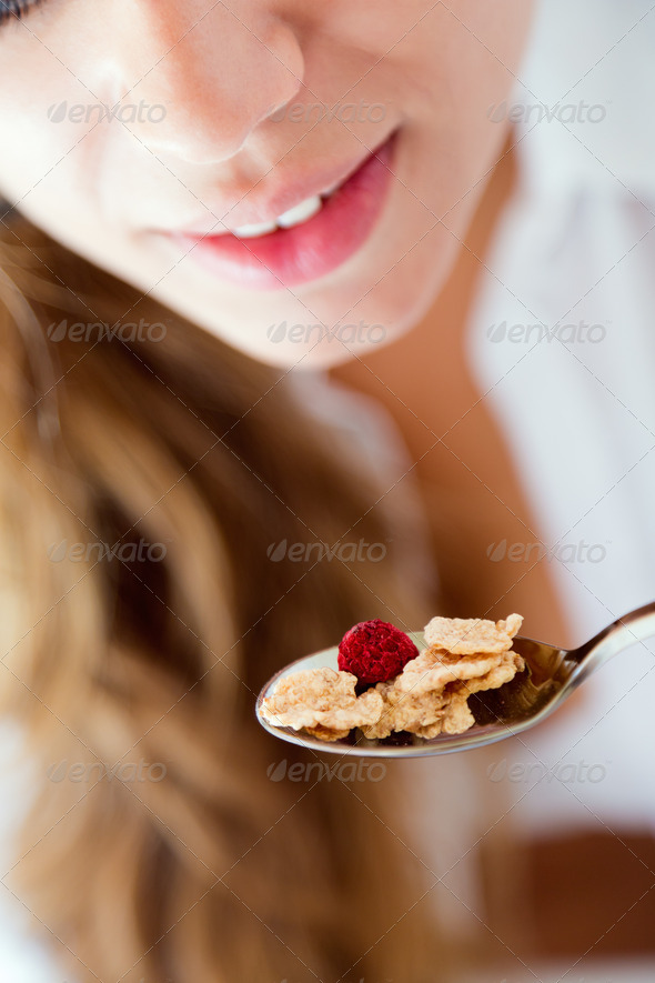 Young woman in underwear eating cereals. Isolated on white. (Misc) Photo Download