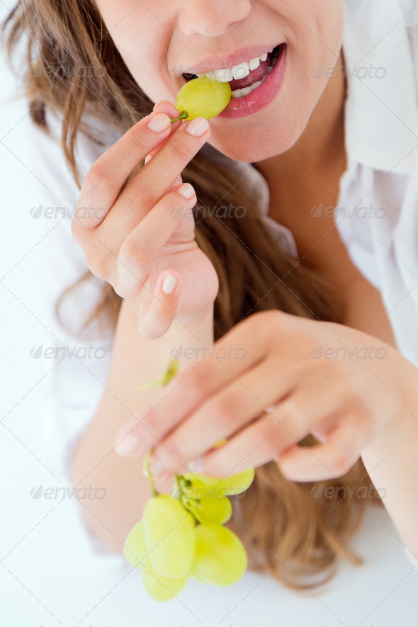 Young woman in underwear eating grapes. Isolated on white. (Misc) Photo Download