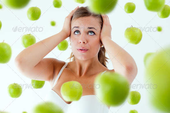 Young girl overwhelmed by diet, surrounded by apples. (Misc) Photo Download