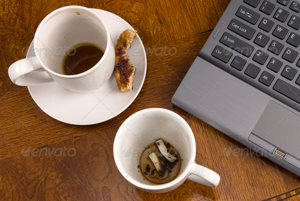 Coffee mugs and stress with laptop