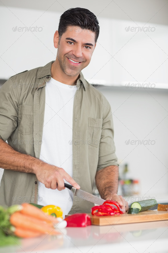 Portrait of a smiling man chopping vegetables in the kitchen at home (Misc) Photo Download