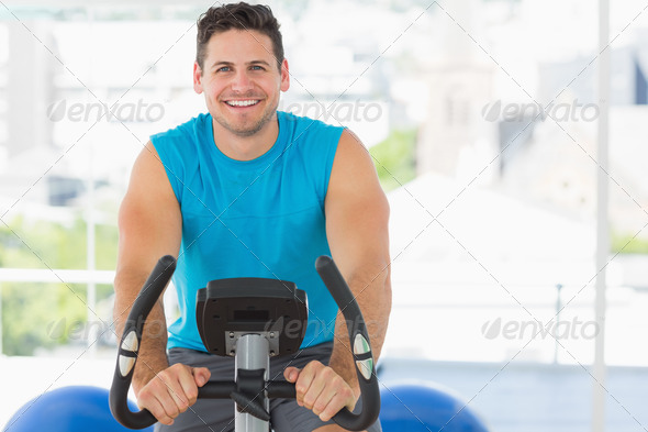 Portrait of a smiling young man working out at spinning class in gym (Misc) Photo Download