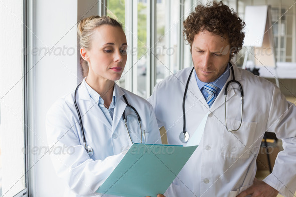 Doctors discussing over file in hospital (Misc) Photo Download