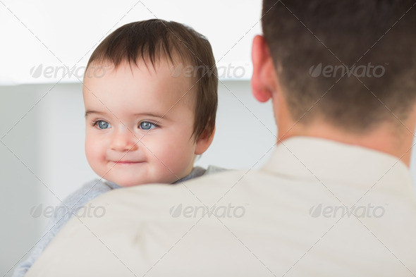 Cute baby boy being carried by father at home (Misc) Photo Download