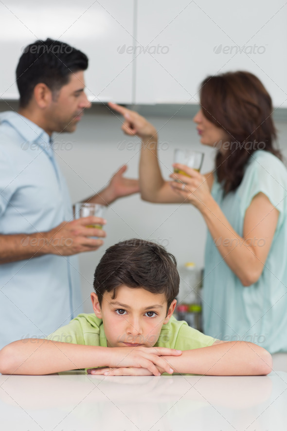 Closeup portrait of a sad son while parents quarreling in the kitchen (Misc) Photo Download