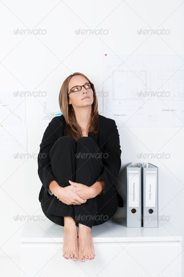 Barefoot businesswoman sitting thinking