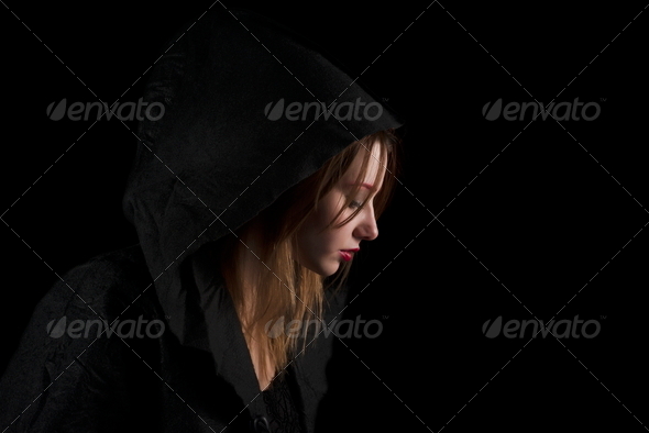 Portrait Of Beautiful Young Woman Wearing Black Hood Over Black Background