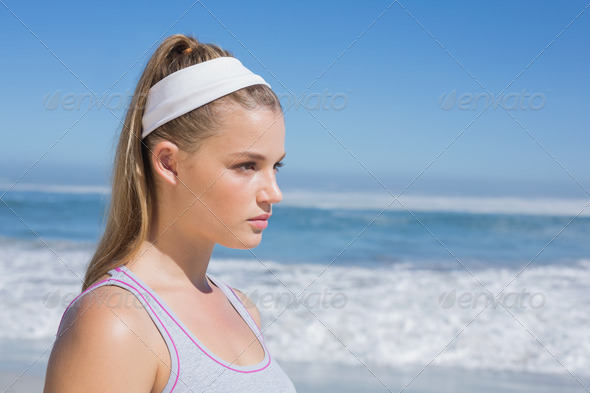 Sporty serious blonde standing on the beach on a sunny day (Misc) Photo Download