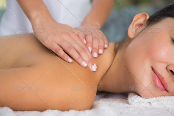 Content brunette getting a back massage at the spa (Misc) Photo Download