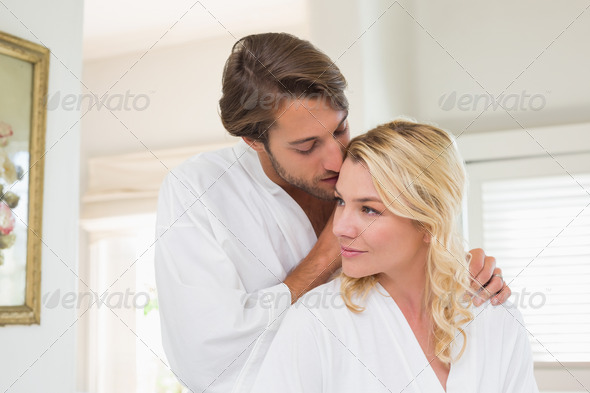 Cute couple in bathrobes spending time together at home in the living room (Misc) Photo Download