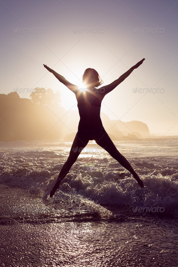 Happy blonde in the sea leaping in bikini on a sunny day (Misc) Photo Download