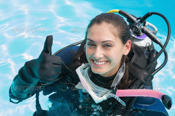 Smiling woman on scuba training in swimming pool showing thumbs up on a sunny day (Misc) Photo Download