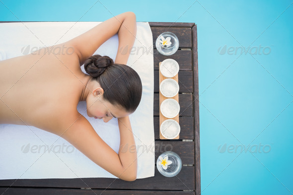 Peaceful brunette lying poolside on towel outside at the spa (Misc) Photo Download