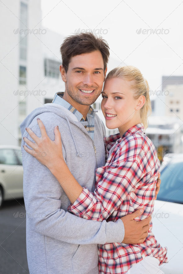 Hip young couple hugging smiling at camera on a sunny day in the city (Misc) Photo Download