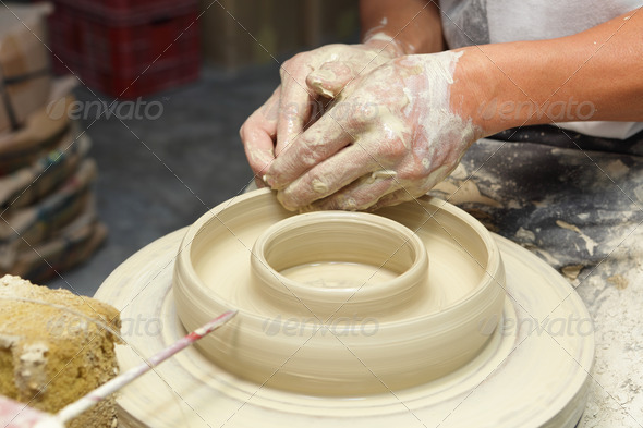 Potter shaping clay in pottery