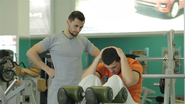 Fitness Trainer Shows a Young Man Fitness Trainer Shows a Young Man