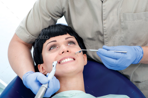 Dental drill drills female tooth. Dentist makes the process of t