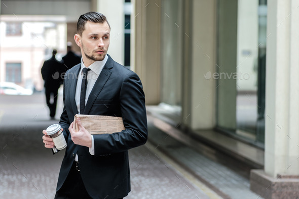 No time to rest. Confident businessman holding a newspaper and c