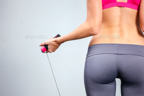 Young woman with jumping rope in her hand.
