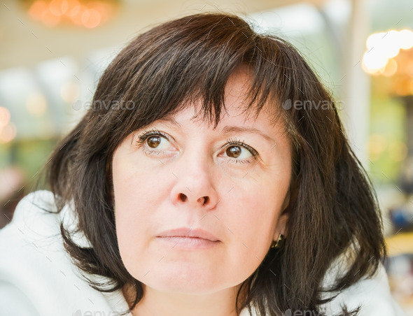 middle-aged woman brown eyes is sitting in the apartment (Misc) Photo Download