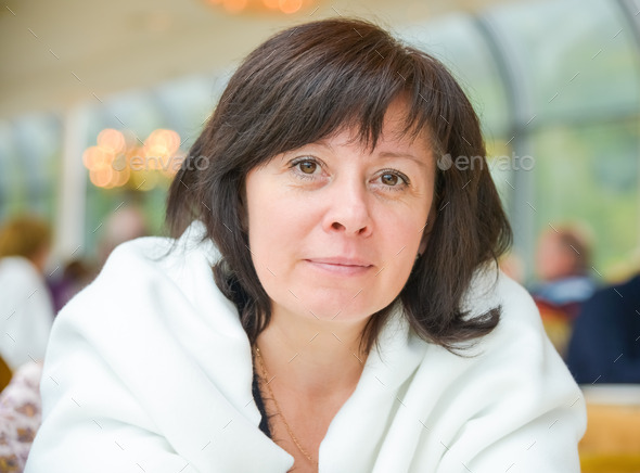 middle-aged woman brown eyes is sitting in the apartment (Misc) Photo Download