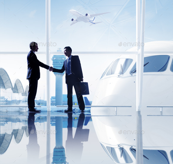 Two Businessmen Shaking Hands In An Airport