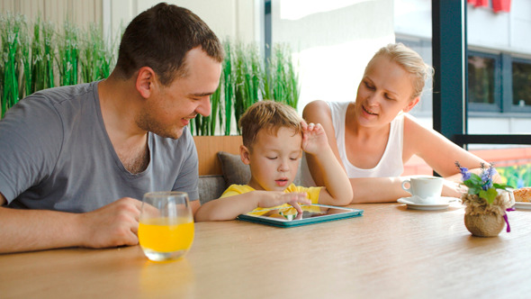 Family Of Three With Pad In Cafe Family Of Three With Pad In Cafe