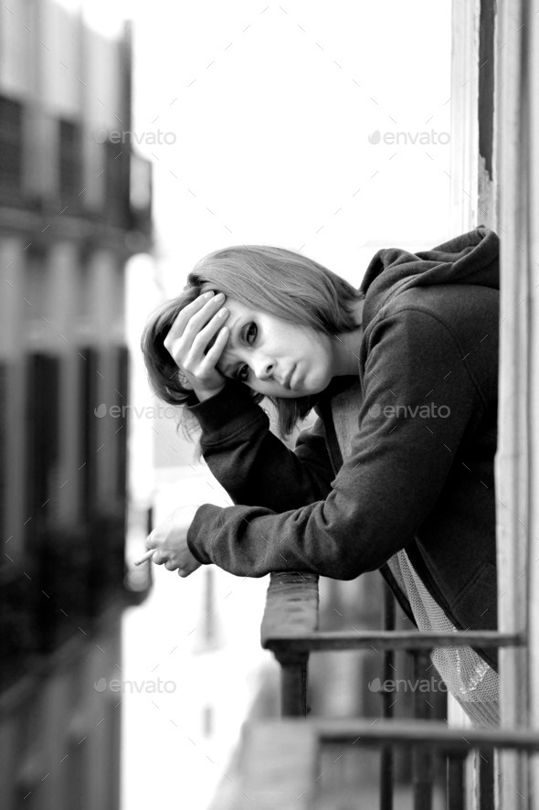 attractive woman suffering depression and stress alone in pain smoking at balcony (Misc) Photo Download