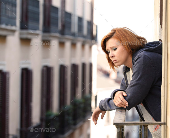 attractive woman suffering depression and stress alone in pain smoking at balcony (Misc) Photo Download