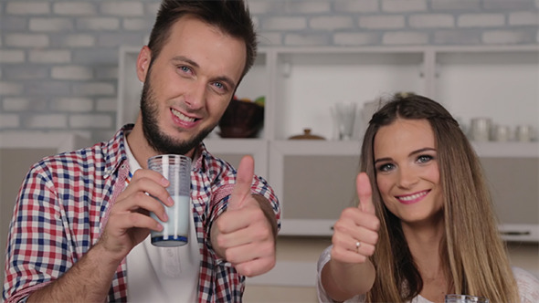 Young Loving Couple Drinking Milk in the Kitchen Young Loving Couple Drinking Milk in the Kitchen