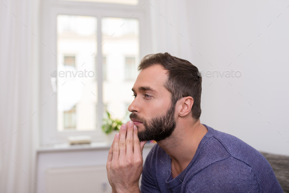 Worried bearded man sitting thinking