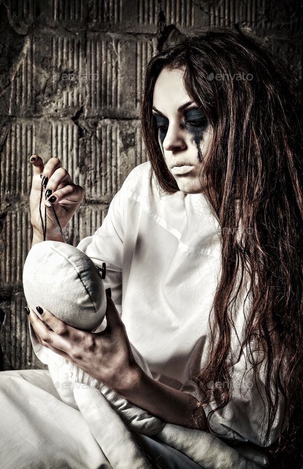 Horror scene: strange crazy girl with moppet doll and needle in hands (Misc) Photo Download