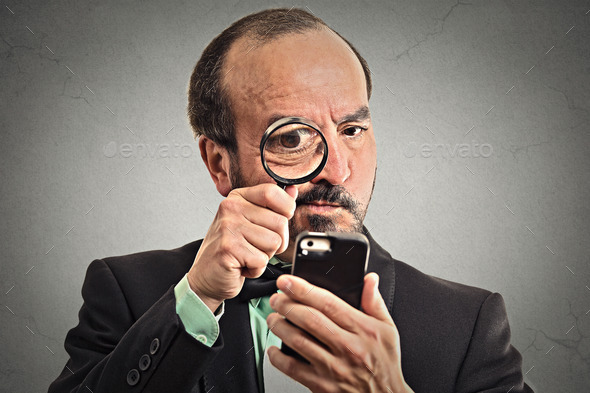 Man Looking through Magnifying Glass on Smartphone (Misc) Photo Download