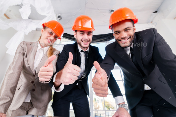 Architects show thumbs up. Three businessm?n architect met in t