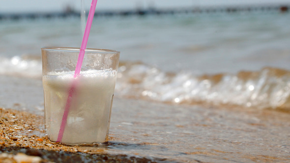 Pouring Fizzy Drink Into Glass On The Sand Pouring Fizzy Drink Into Glass On The Sand