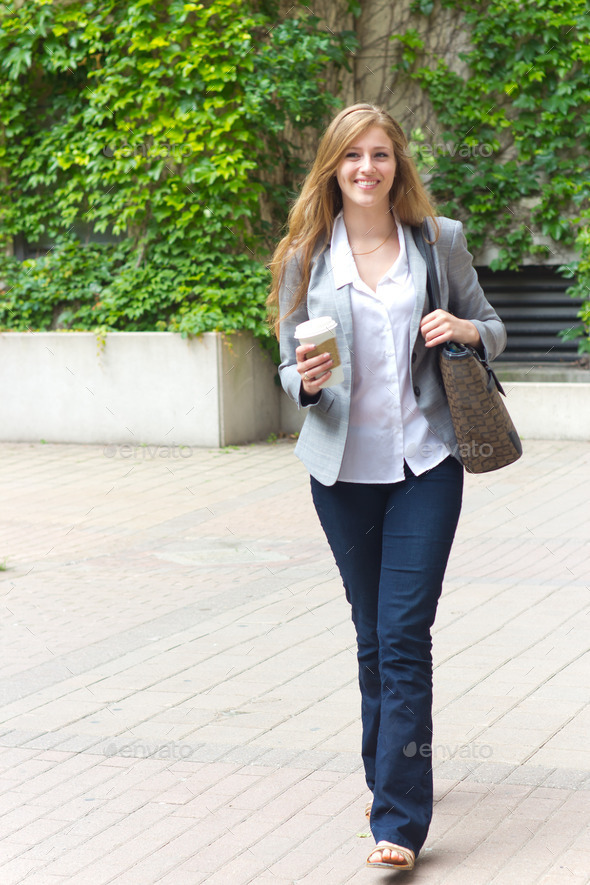 Young woman walking with coffee
