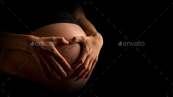 Pregnant Woman Showing Heart Tattoo on Belly