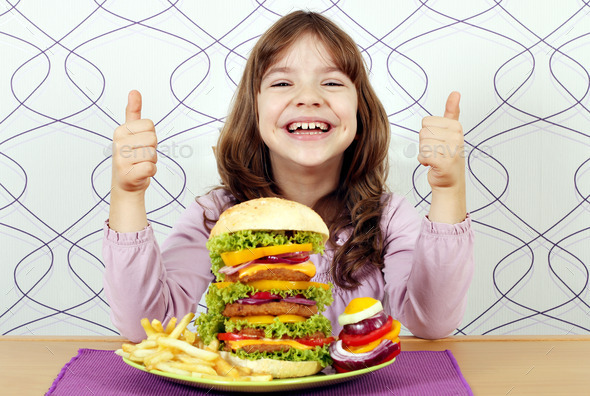 happy little girl with big hamburger and thumbs up